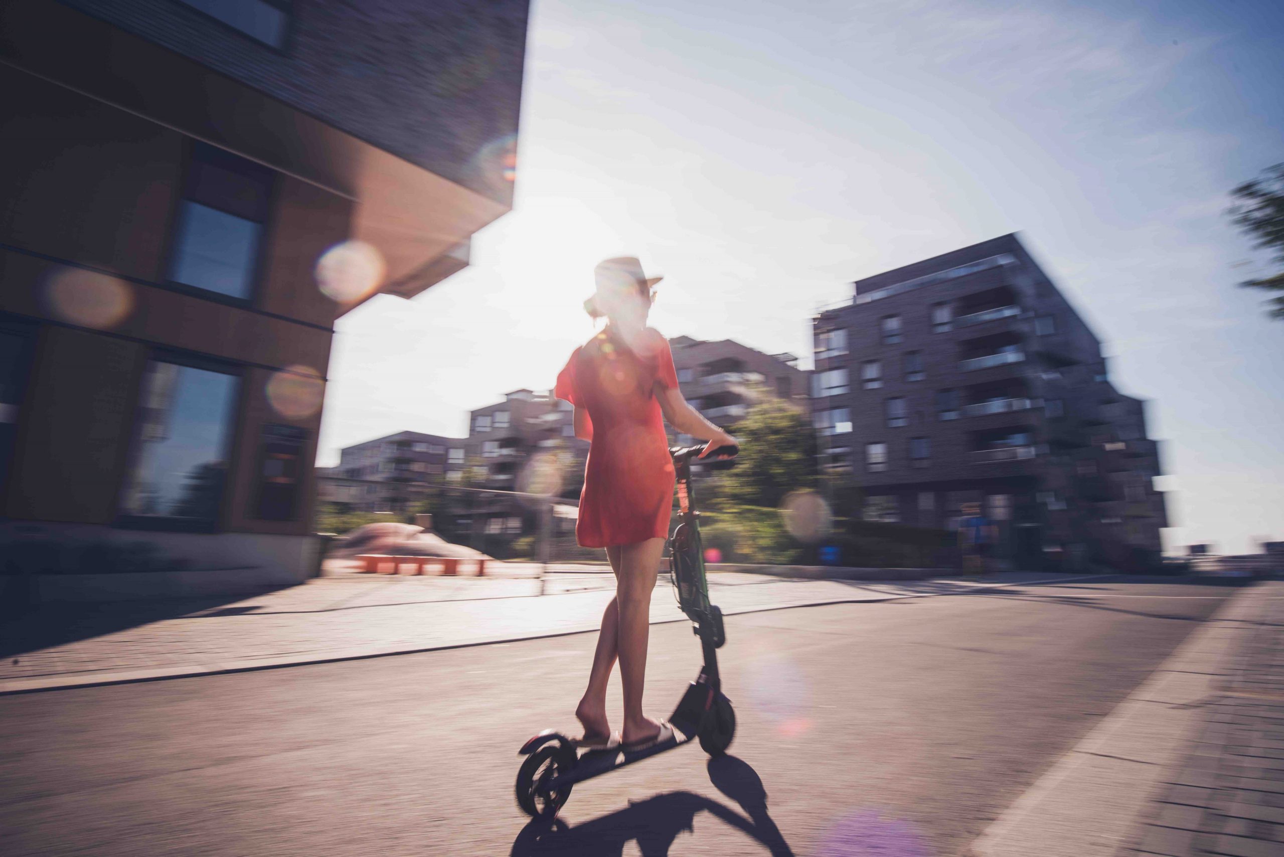 Rear view of female on electric scooter.